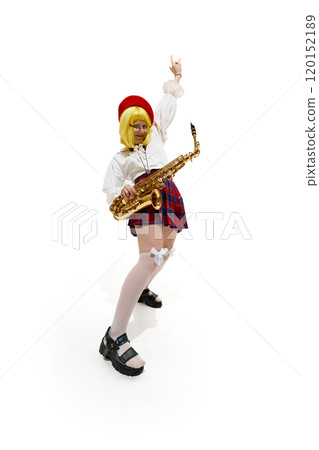 Woman with yellow wig, red beret, and glasses, holding saxophone, one arm raised in rock 'n' roll gesture against white studio background. 120152189