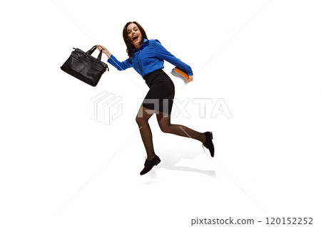 Happy, excited young woman, dressed official outfit running in motions, as if end of day against white studio background. 120152252