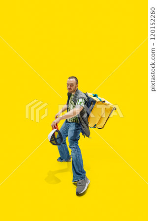 Man, courier with backpack on back raising hand with hat, exuding happy against vibrant yellow background. 120152260