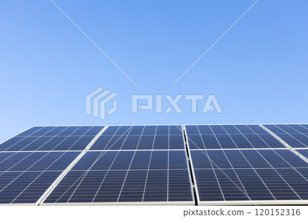 Aerial view of solar panel cells on clear blue sky background. Alternative energy concept. Modern house with solar panels stand-alone photovoltaic plant system on household metal sheet roof Aerial view of solar panel cells on clear blue sky background. Alternative energy concept. Modern house with solar panels stand-alone photovoltaic plant system on household metal sheet roof 120152316