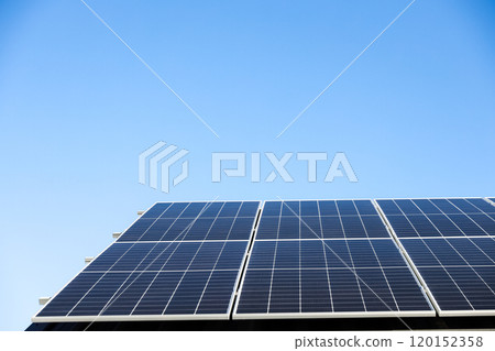 Aerial view of solar panel cells on clear blue sky background. Clean alternative energy power concept, sustainable resources. Modern house, solar panels stand-alone photovoltaic plant system on roof 120152358