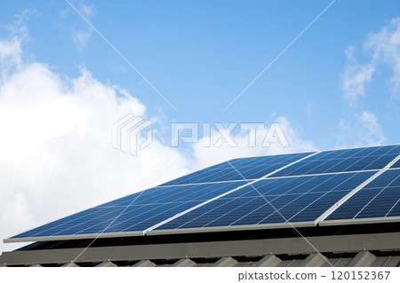 Aerial view of solar panel cells against cloudy blue sky. Alternative energy concept, sustainable resources. House with solar panels stand-alone photovoltaic plant system. Professional installation 120152367
