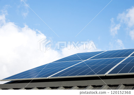 Aerial view of solar panel cells against cloudy blue sky. Alternative energy concept, sustainable resources. House with solar panels stand-alone photovoltaic plant system. Professional installation 120152368