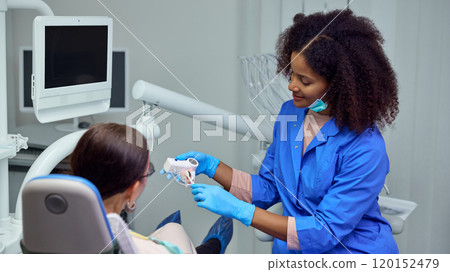 Dentist provides post-treatment instructions, advising on how to care for treated area to support healing. Dentist provides post-treatment instructions, advising on how to care for treated area to support healing. 120152479