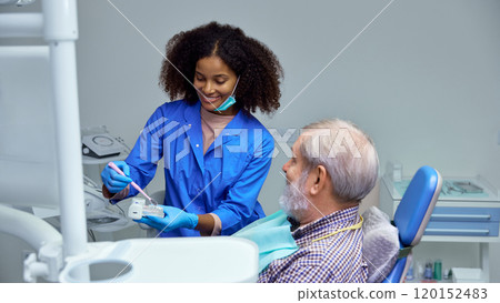 Dentist explains benefits of dental veneers, detailing how it can improve patient's smile and dental confidence. Dentist explains benefits of dental veneers, detailing how it can improve patient's smile and dental confidence. 120152483
