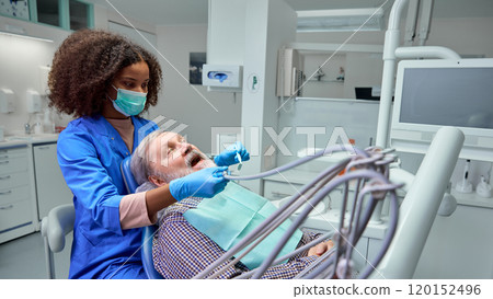 Dentist demonstrates correct brushing techniques, showing patient practical steps to maintain healthy teeth between visits. Dentist demonstrates correct brushing techniques, showing patient practical steps to maintain healthy teeth between visits. 120152496