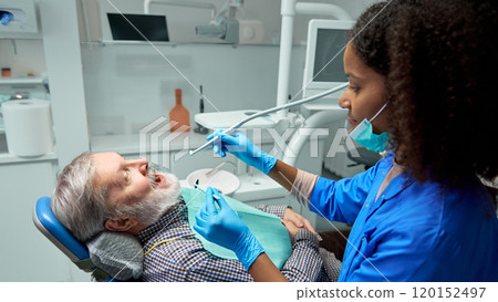 Dentist demonstrates correct brushing techniques, showing patient practical steps to maintain healthy teeth between visits. 120152497