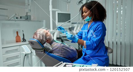 Dentist shows brushing techniques with toothbrushes, emphasizing importance of proper oral hygiene. 120152507