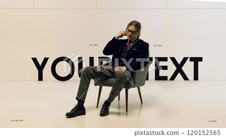Young man in suit with red tie sitting in armchair against minimalist backdrop with bold typography. Advertising, branding designs with space for text overlay. Young man in suit with red tie sitting in armchair against minimalist backdrop with bold typography. Advertising, branding designs with space for text overlay. 120152565