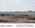 Polluted area of the municipal landfill with cityscape in smog in the background  120152842
