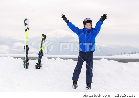 Young Kid Skier Joyfully Celebrating on Snow-Covered Mountain During Winter 120153133
