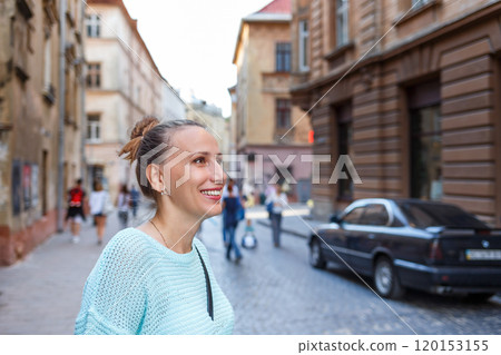 Smiling woman enjoying a sunny day in a charming European street with historical architecture Smiling woman enjoying a sunny day in a charming European street with historical architecture 120153155