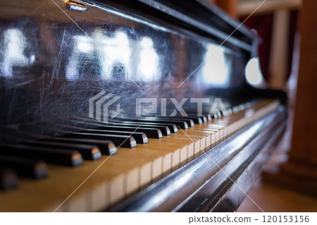A Close-Up View of a Vintage Piano's Keys in a Softly Lit Room A Close-Up View of a Vintage Piano's Keys in a Softly Lit Room 120153156