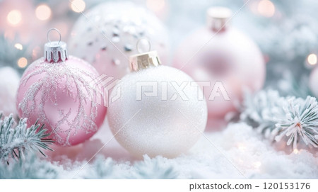 glittery pink and white Christmas ornaments lies on a bed of snow, surrounded by frosted branches 120153176