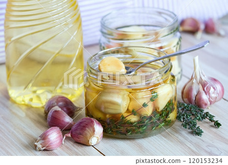 Garlic cloves pickled in sunflower oil and thyme. 120153234
