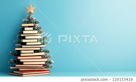 A creative arrangement of books stacked in the shape of a Christmas tree topped with a star against a blue background 120153419