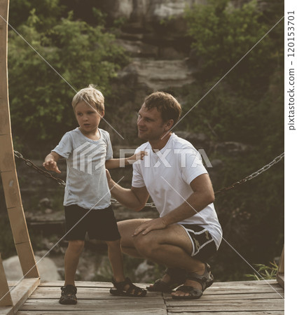Vintage matte effect photo. Happy lifestyle moment. Man crouched, gesture hand, attentive listen boy walk funny play. Father hug hold touch child son closely in arms embrace, fatherhood love affection Vintage matte effect photo. Happy lifestyle moment. Man crouched, gesture hand, attentive listen boy walk funny play. Father hug hold touch child son closely in arms embrace, fatherhood love affection 120153701