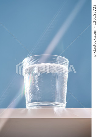 Glass of clean filtered water on blue background with beautiful glare. 120153722