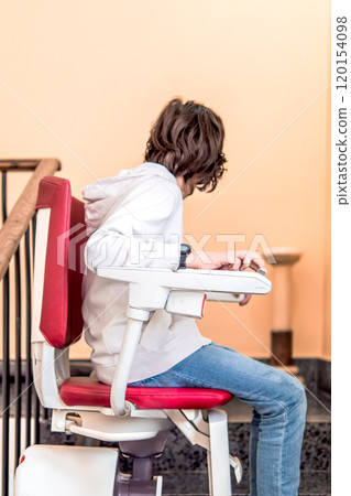 Child Using Stairlift on Indoor Staircase Child Using Stairlift on Indoor Staircase 120154098