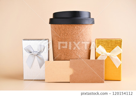 Eco-Friendly Coffee Cup with Gift Boxes Minimalist Holiday Gift Concept. tylish image featuring an Eco-Friendly Coffee Cup with Gift Boxes Minimalist Holiday Gift Concept. tylish image featuring an 120154112