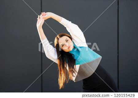 Cute sporty girl doing stretching on the street before training Cute sporty girl doing stretching on the street before training 120155429