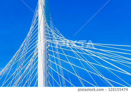 White metal cable-stayed bridge details are under clear blue sky White metal cable-stayed bridge details are under clear blue sky 120155474