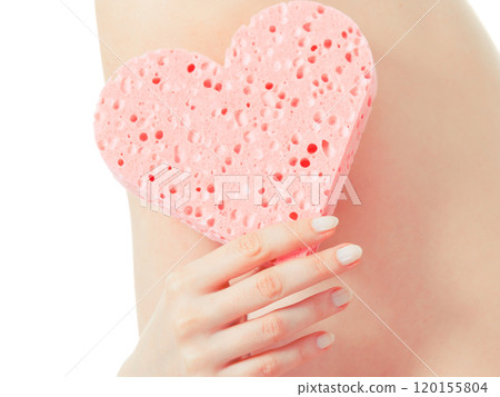 woman holding heart sponge closeup 120155804