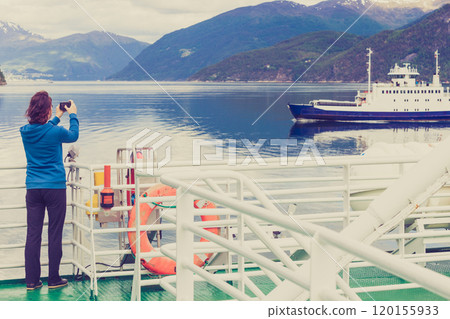 Tourist woman on liner taking photo, Norway 120155933