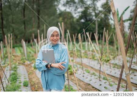 Young Woman in Agricultural Field with Laptop and Modern Farming Tools Young Woman in Agricultural Field with Laptop and Modern Farming Tools 120156260
