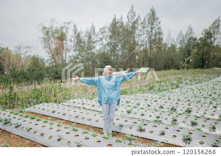 The Joyful Gardener Fully Embracing the Beauty of Nature in a Vibrant Green Field 120156268