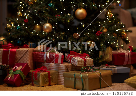 Closeup background image of Christmas presents piled under Christmas tree in gold and red traditional festive colors copy space 120156788