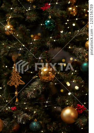 Vertical background image of glittering Christmas tree decorated with golden baulbs copy space 120156789