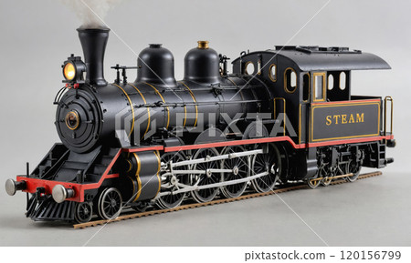 A black steam locomotive with red accents is ready to chug along the tracks 120156799
