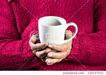 Adult woman with red sweater holding a cup of latte coffee Adult woman with red sweater holding a cup of latte coffee 120157532