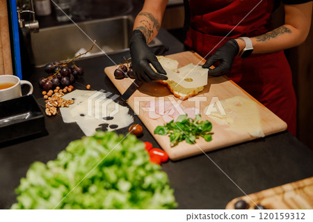 A chef is making a delicious sandwich with fresh ingredients to create something special 120159312