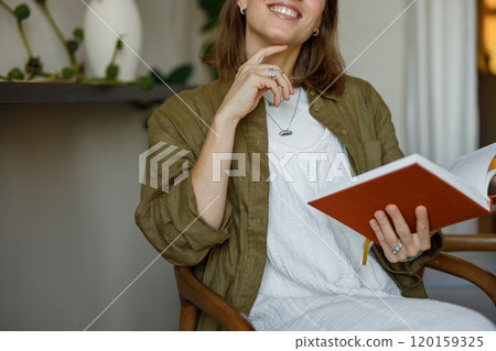 A Thoughtful and Reflective Woman Enjoying a Good Book in a Cozy, Inviting Setting A Thoughtful and Reflective Woman Enjoying a Good Book in a Cozy, Inviting Setting 120159325