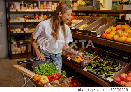 A woman shops for fresh produce at a bustling market, engaging with her community A woman shops for fresh produce at a bustling market, engaging with her community 120159329