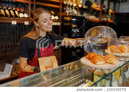 A Friendly Barista Serving Delicious Pastries in a Warm and Cozy Cafe Environment A Friendly Barista Serving Delicious Pastries in a Warm and Cozy Cafe Environment 120159379