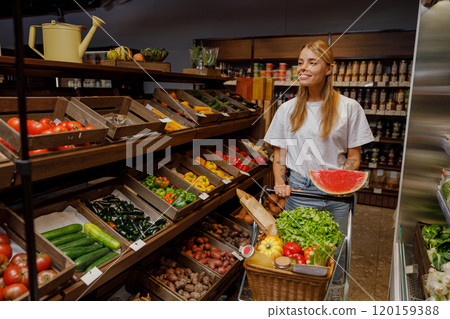 A woman is shopping in an organic grocery store, surrounded by an array of fresh, vibrant produce A woman is shopping in an organic grocery store, surrounded by an array of fresh, vibrant produce 120159388