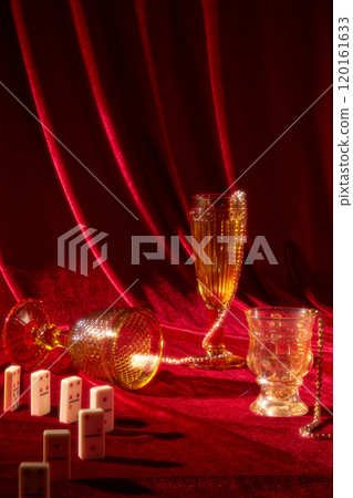 The template image has a frontal view of variously shaped and colored glasses with gold jewelry, encircled by red-surfaced dominoes, making appropriate for a New Years Eve theme on a red background. 120161633
