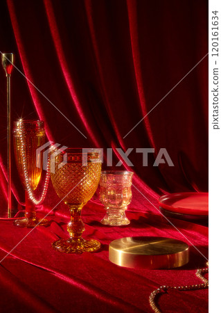 Ideal for the New Year party theme, a template features a red silk backdrop, a close-up of glass cups, pearl strings, a brass candle holder, a brass podium, and gold jewelry around a crimson surface. 120161634