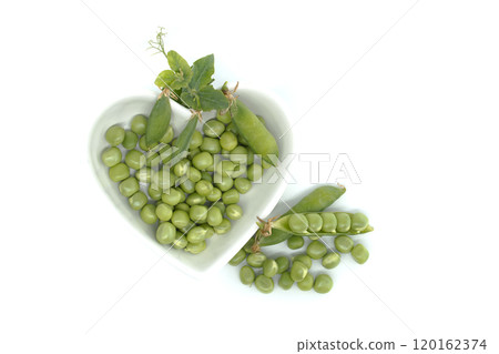 Fresh green peas in a heart-shaped bowl isolated on white background Fresh green peas in a heart-shaped bowl isolated on white background 120162374