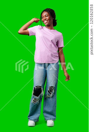 Joyful woman celebrating success with clenched fists against a bright green background Joyful woman celebrating success with clenched fists against a bright green background 120162858