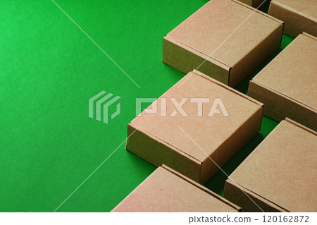 Brown cardboard boxes arranged on a vibrant green surface Brown cardboard boxes arranged on a vibrant green surface 120162872
