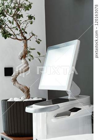 Modern medical equipment in a bright waiting area featuring a potted plant Modern medical equipment in a bright waiting area featuring a potted plant 120163078