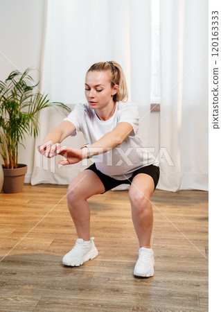 Woman performing a stretching exercise in a bright indoor 120163333