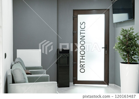 Welcoming orthodontic office with modern decor and comfortable seating area for patients 120163487