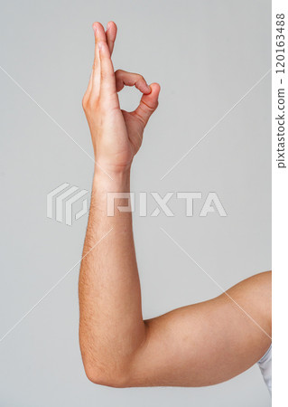 A person hand gesture against a neutral background 120163488