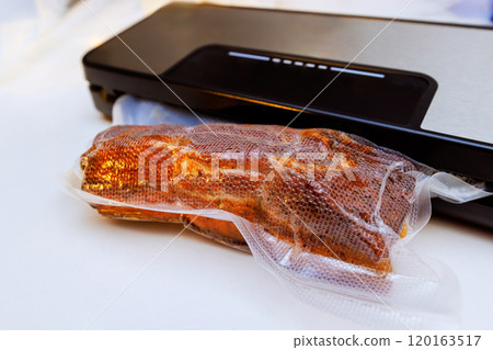 Piece of smoked meat is being placed into vacuum sealer bag, method of food quality, keeping food fresh preventing spoilage 120163517