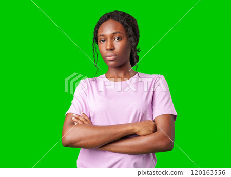 Young woman with an expression of contemplation poses against a bright green background Young woman with an expression of contemplation poses against a bright green background 120163556